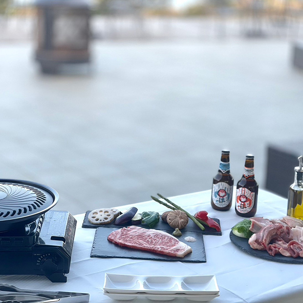 テラス席にグリルセットのお肉や野菜と瓶ビール