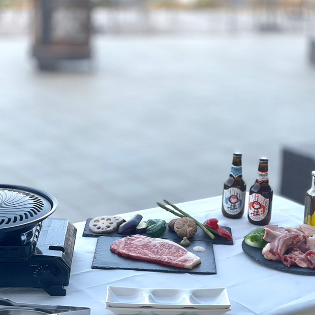 テラス席にグリルセットのお肉や野菜と瓶ビール